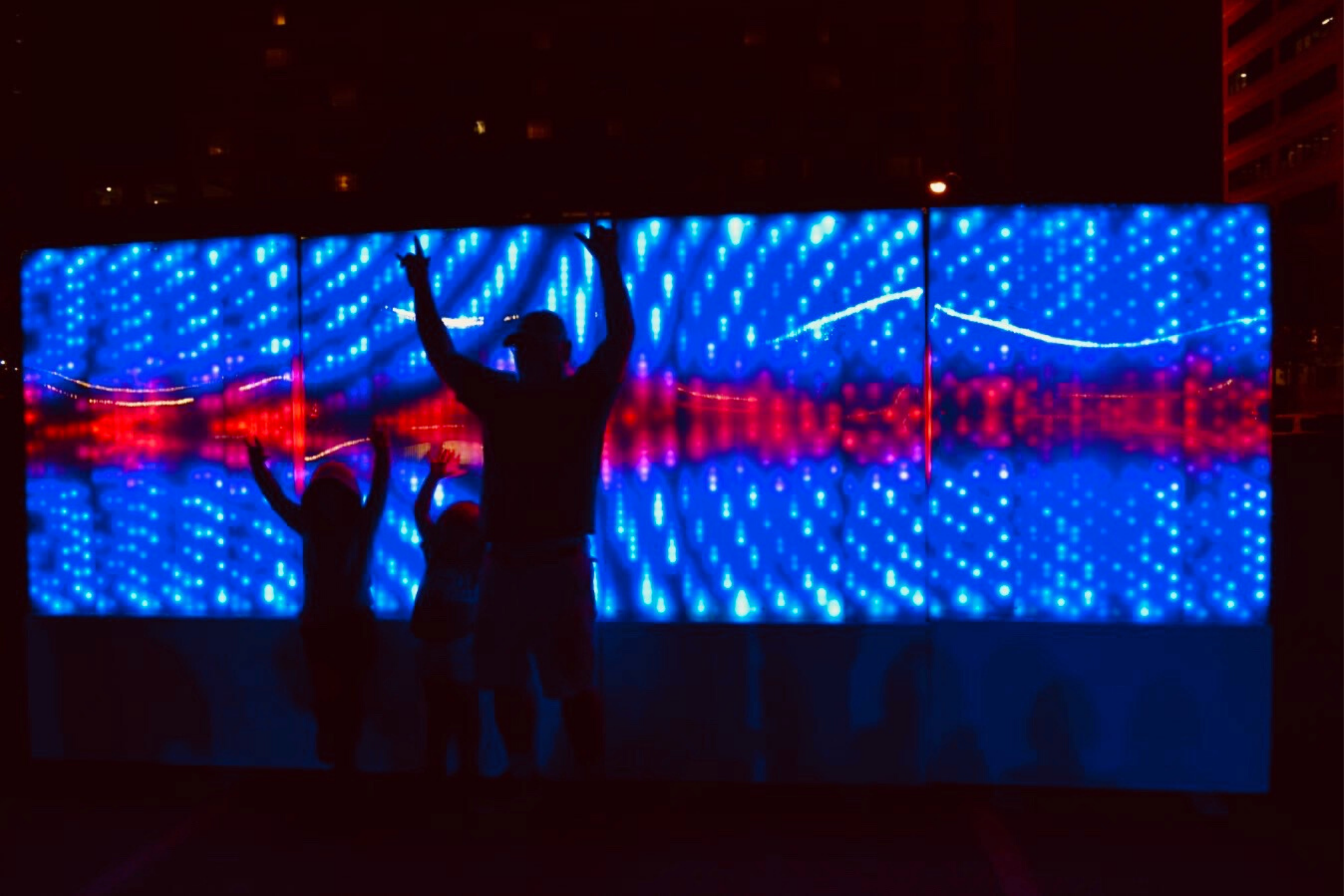 Family taking selfie with light art