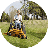 Turf A man using a riding lawnmower to cut grass
